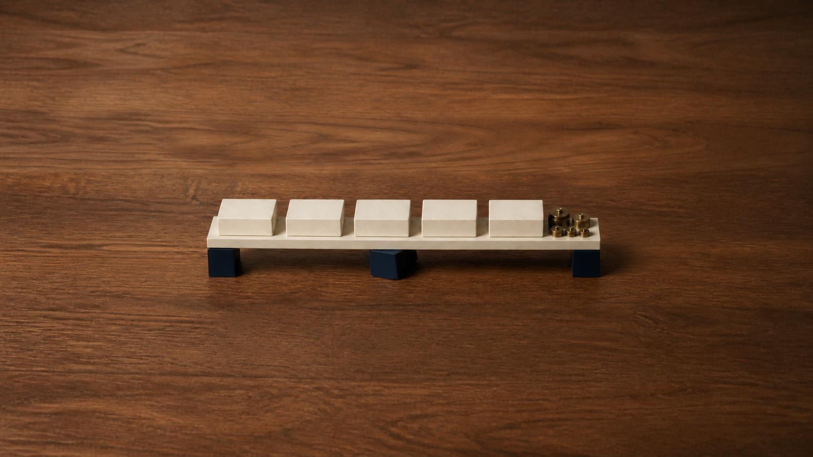 Identical cream blocks on a platform with brass weights and a misaligned navy support